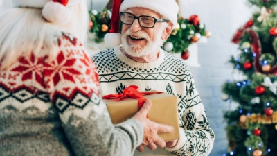 Un grand-père et sa petite-fille qui s'offrent des cadeaux à Noël