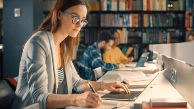 une jeune fille étudie dans une bibliothèque