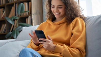 Jeune fille souriante assise dans un canapé