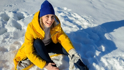 Femme souriant après être tombée dans la neige