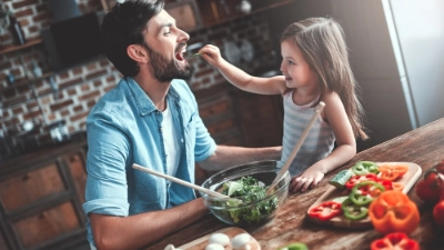 Un père et sa fille cuisinent des légumes