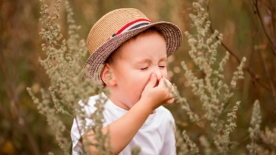 petit garçon qui éternue à cause du pollen