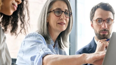 femme devant un ordinateur discute avec ses collègues de bureau