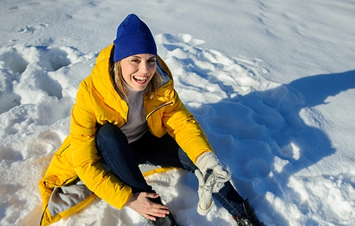 Femme souriant après être tombée dans la neige